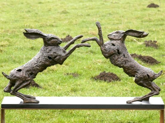 Batalla-duel is een bronzen beeld van twee vechtende hazen | bronzen beelden en tuinbeelden, figurative bronze sculptures van Jeanette Jansen |